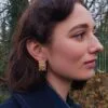 Zoom sur les boucles d'oreilles clips vintage en maille dorée.