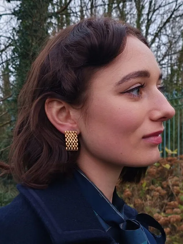 Zoom sur les boucles d'oreilles clips vintage en maille dorée.