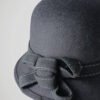 Zoom sur le noeud du chapeau melon gris pour femme.