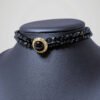 Zoom sur le chocker vintage noir et doré, vue de côté.