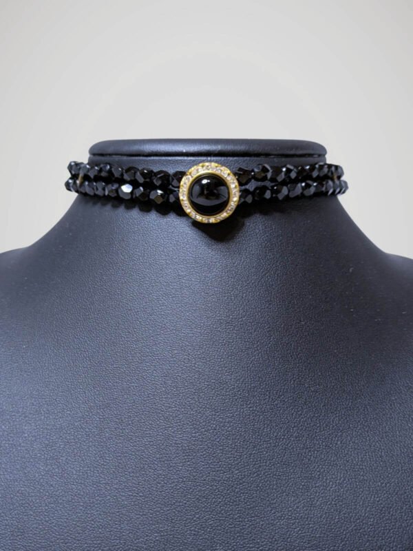 Zoom sur le chocker vintage noir et doré, vue de face.