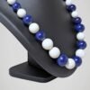 Zoom sur le collier vintage de perles bleues marine et blanches, vue de côté.