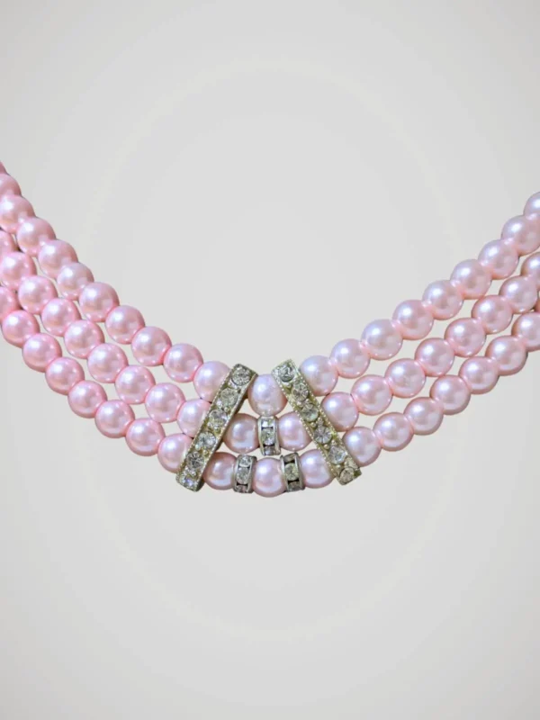 Zoom sur le collier vintage à trois rangs de perles roses nacrées et brillants, vue de face.