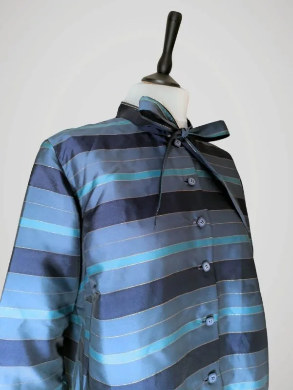 blouse-rayee-bleue-vintage-faite-main-face-zoom Zoom sur la blouse vintage années 70 pour femme, faite main, à rayures bleues et dorées, taille S à M, vue de côté.