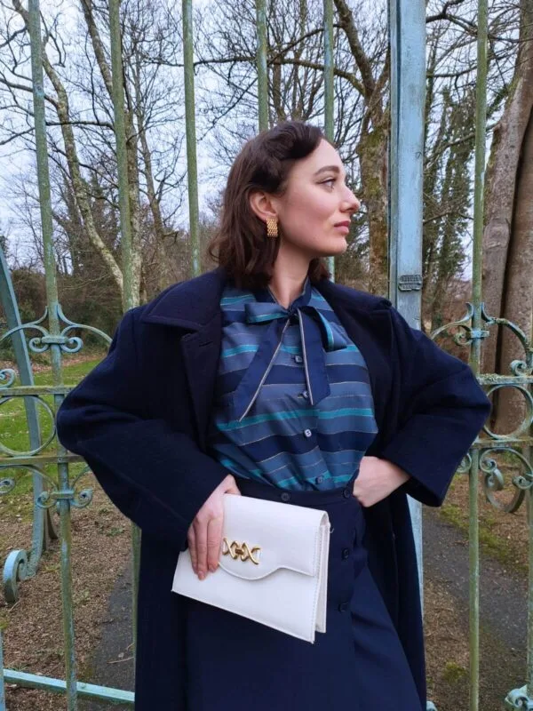 blouse-rayee-bleue-vintage-faite-main-portee Blouse vintage années 70 pour femme, faite main, à rayures bleues et dorées, taille S à M, portée par une femme à l'allure vintage.