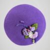 Béret mauve en laine orné d'une broche thème lavande, fait main, vue de face.
