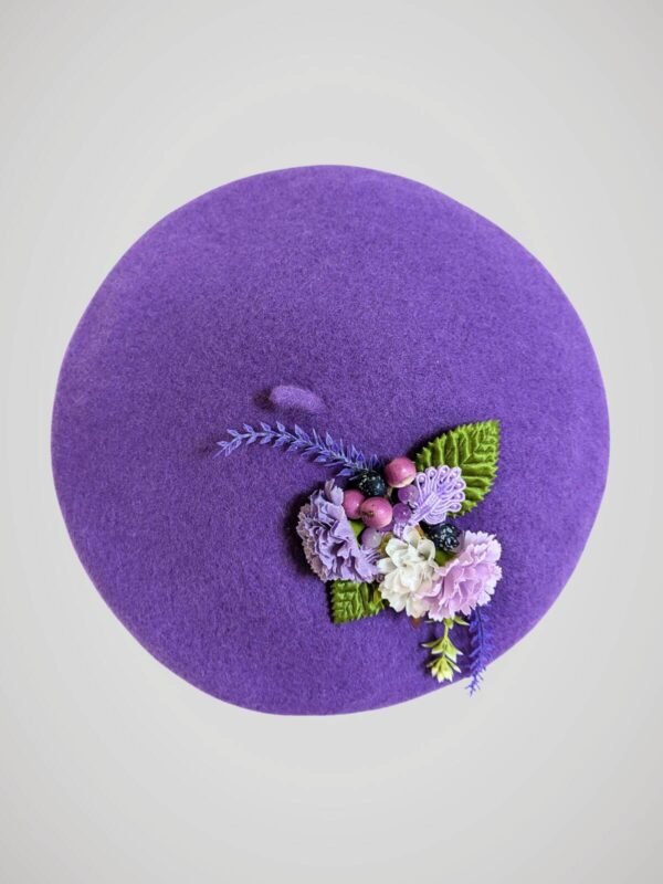 Béret mauve en laine orné d'une broche thème lavande, fait main, vue de face.