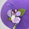 Zoom sur le béret mauve en laine orné d'une broche thème lavande, fait main.