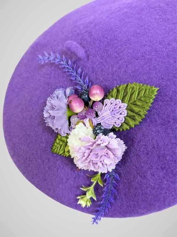 Zoom sur le béret mauve en laine orné d'une broche thème lavande, fait main.