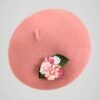 Béret en laine rose orné d'une broche modèle fleurs de cerisier fait main, vue de côté.