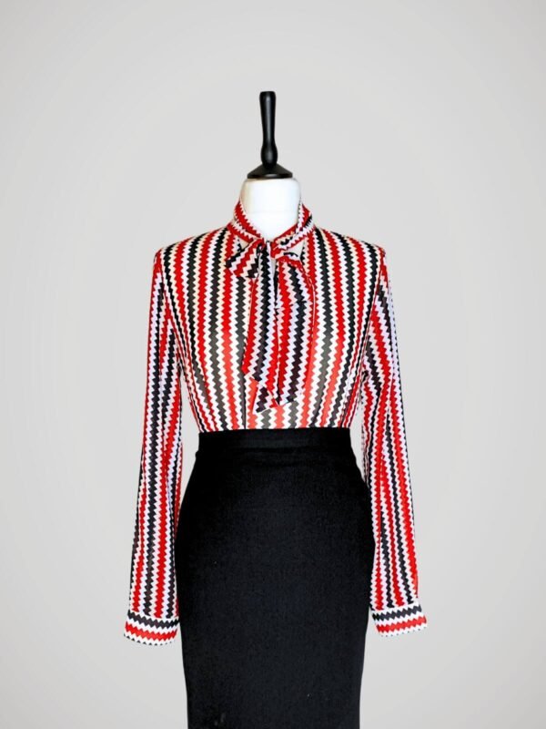 Blouse manches longues à motifs de zigzags rouge, blanc et noir, rétro pour femme, taille S à M, vue de face avec une jupe noire.