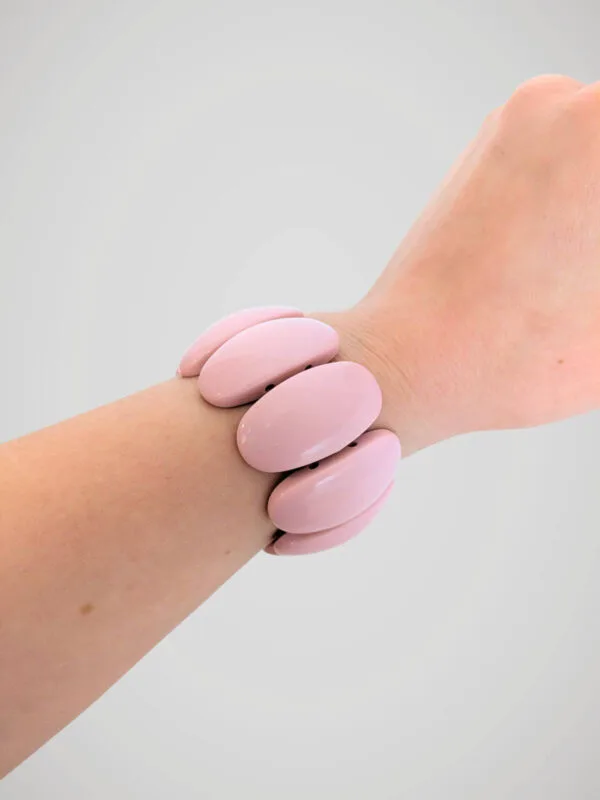 bracelet-manchette-elastique-rose-retro-porte Bracelet manchette élastique rétro à perles roses pastel, porté à un poignet.