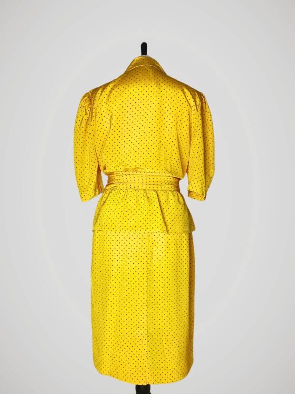 Ensemble composé d'une jupe tailleur et d'un chemisier manches courtes, vintage des années 80, jaune à pois noirs pour femme, taille M à L, vue de dos.