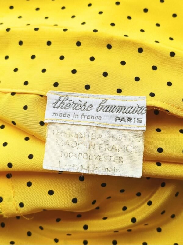 Etiquette de l'ensemble composé d'une jupe tailleur et d'un chemisier manches courtes, vintage des années 80, jaune à pois noirs pour femme, taille M à L.