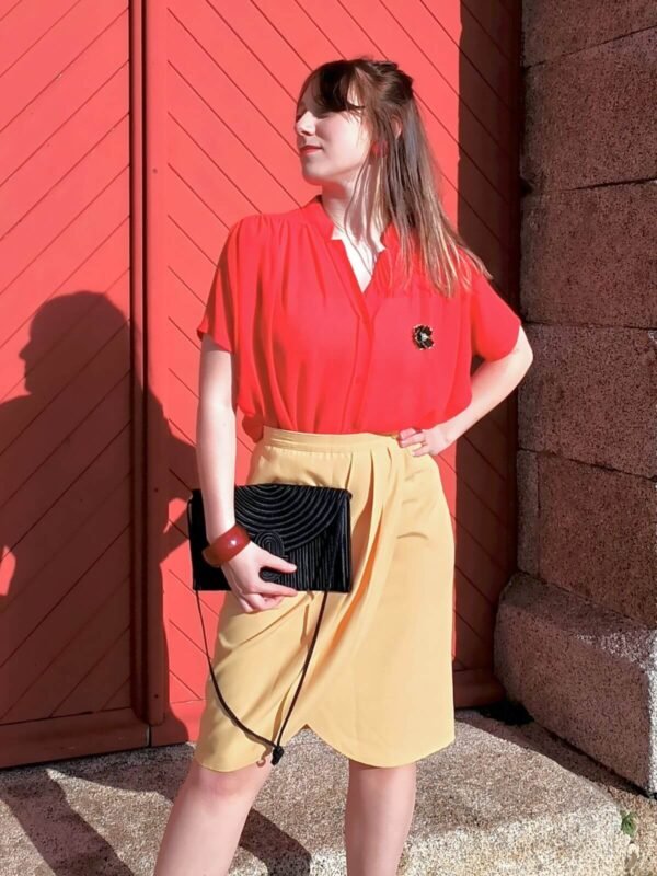 Jupe tailleur portefeuille jaune citron vintage des années 50, faite main, pour femme, taille XS à S, portée par une femme avec la main sur la hanche.
