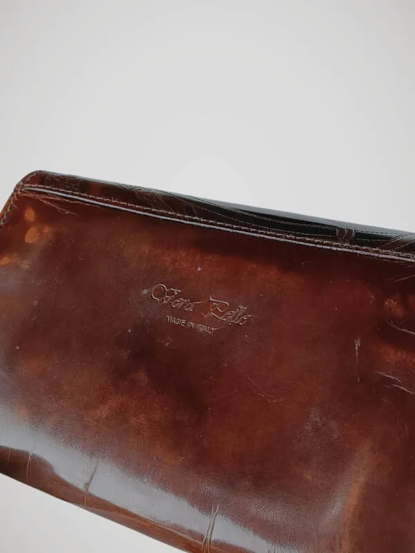 Zoom sur la griffe du porte monnaie en cuir marron Vera Pelle, made in Italy.