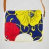 Sac bandoulière vintage des années 60, à motif de fleurs rouges et jaunes sur fond bleu marine, vue de face.