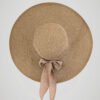 Chapeau de paille large pour femme, style bohème pour l'été, orné d'un noeud, vue de face.