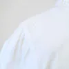 Zoom sur la tâche de la chemise à manches courtes blanche à boutons nacrés, pour femme, vintage des années 80.