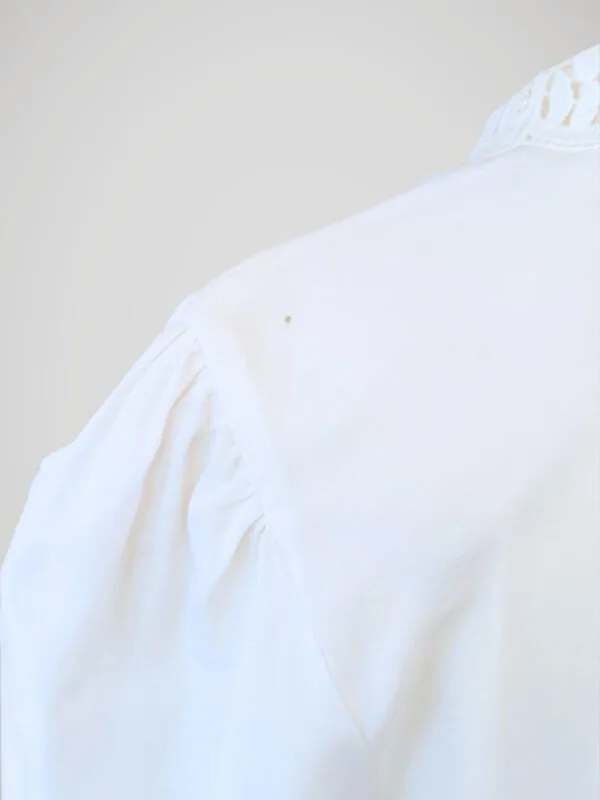 Zoom sur la tâche de la chemise à manches courtes blanche à boutons nacrés, pour femme, vintage des années 80.