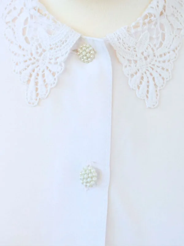 Zoom sur les boutons nacrés de la chemise à manches courtes blanche à boutons nacrés, pour femme, vintage des années 80.