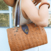 Sac à main en osier et cuir vintage, porté.
