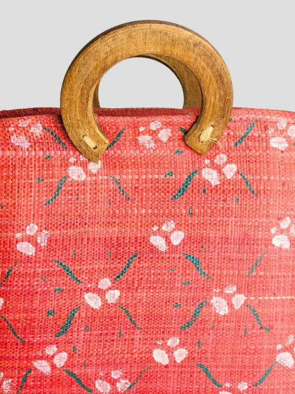 Zoom sur le sac cabas rouge vintage années 50, 60 ou 70, peint à la main, en bois et fibres naturelles.