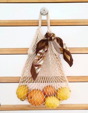 Sac à main pour fruits en filets beiges, vue de face.